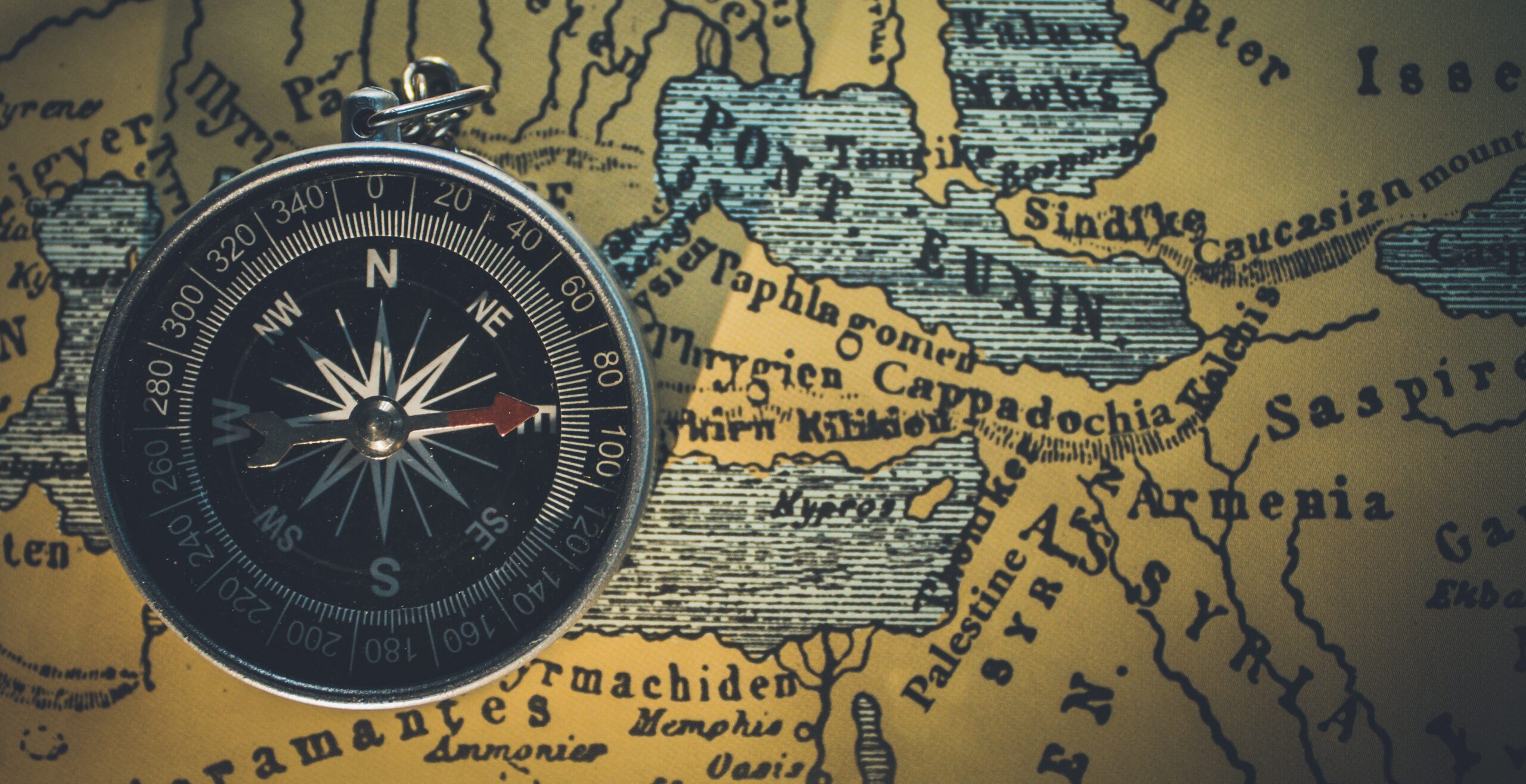 Compass in foreground with old-time map in the background